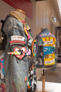 A close-up of a denim jacket covered in colourful badges and appliques.